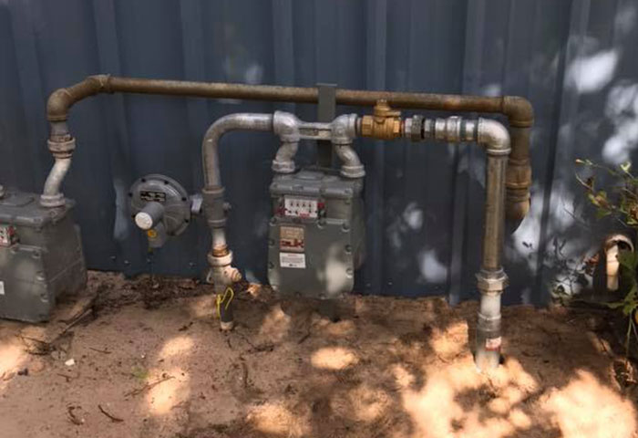 Outdoor gas meter and piping system installed on a wall