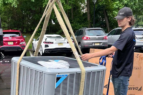 A technician installing or servicing a Daikin AC unit